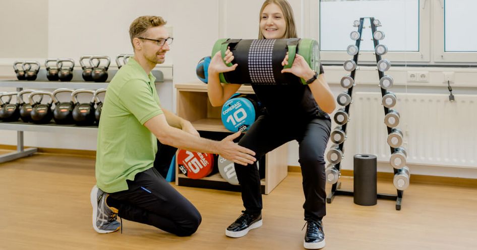 Teilstationäre Orthopädie MEDICLIN Fachklinik Rhein/Ruhr Therapeut und Patientin trainieren mit Bällen