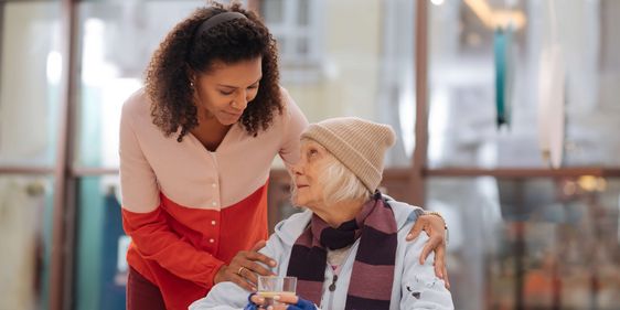 Pflegekraft spricht mit älterer Frau