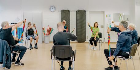 Patienten machen in der Gruppe physiotherapeutische Übungen