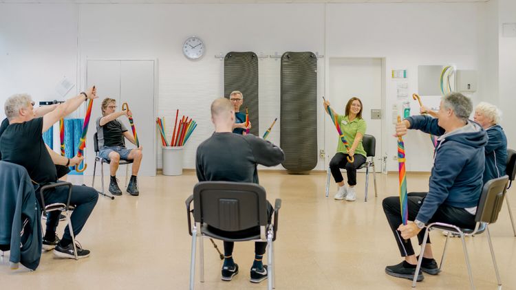 Patienten machen in der Gruppe physiotherapeutische Übungen