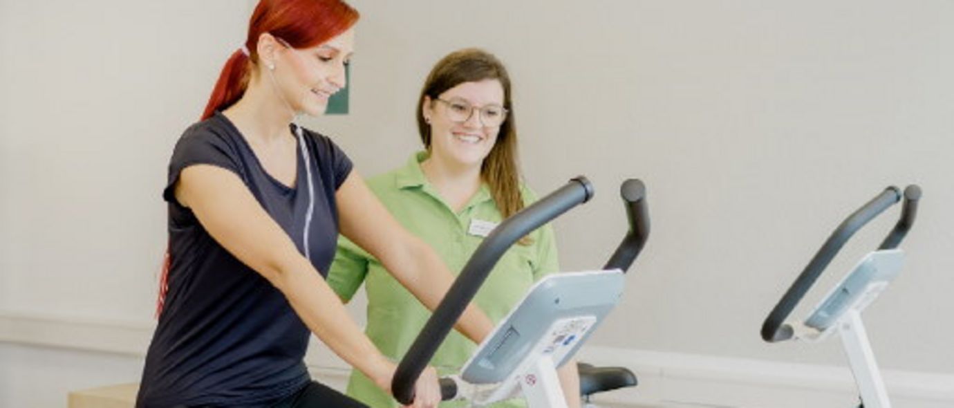 Therapeutin begleitet Patientin beim Ergometertraining