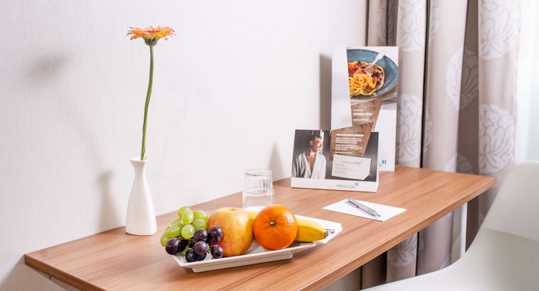 mit Obstchale und Blumen gedeckter Tisch im Wahlleistungszimmer