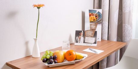 mit Obstchale und Blumen gedeckter Tisch im Wahlleistungszimmer