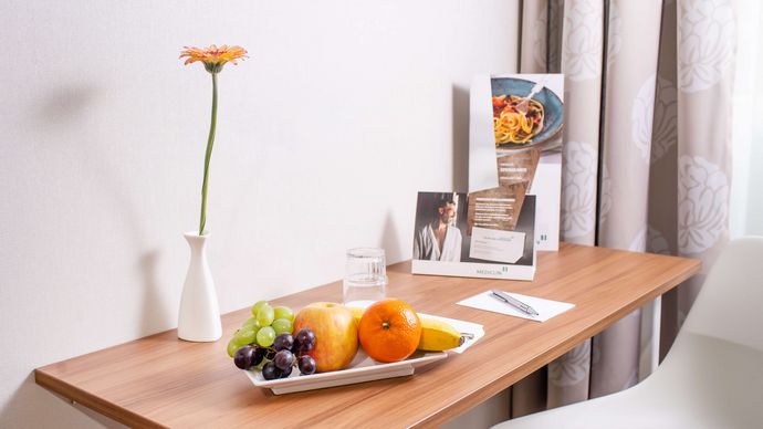 mit Obstchale und Blumen gedeckter Tisch im Wahlleistungszimmer