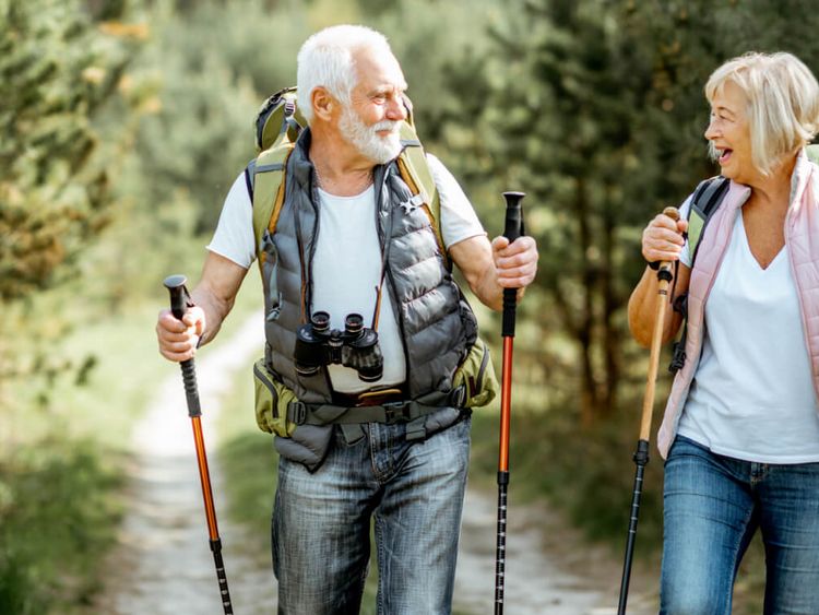 ein fröhliches älteres Ehepaar wandert durch den Wald