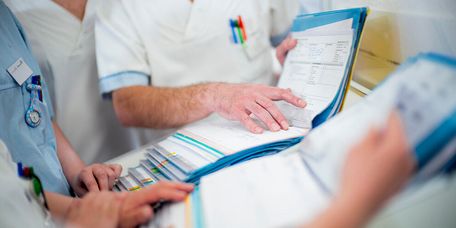 Pflegekräfte besprechen Patientenakten bei der Übergabe