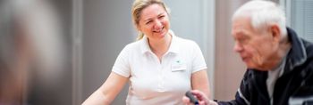 Logopädin und älterer Patient legen Worte aus Buchstaben