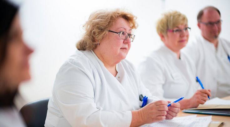 Ärzte besprechen Patientenakten in einer Fallkonferenz
