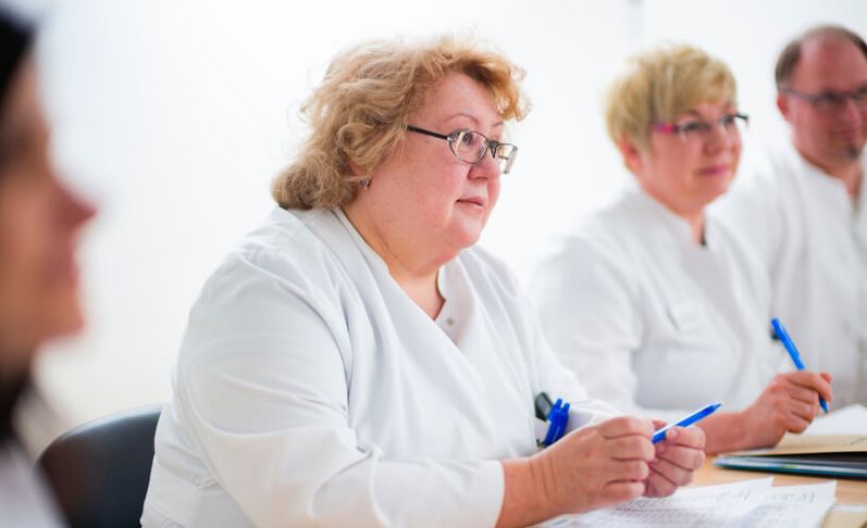 Ärzte besprechen Patientenakten in einer Fallkonferenz