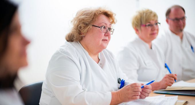 Ärzte besprechen Patientenakten in einer Fallkonferenz