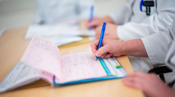 Arzt und Pflegekraft füllen Patientenakte aus